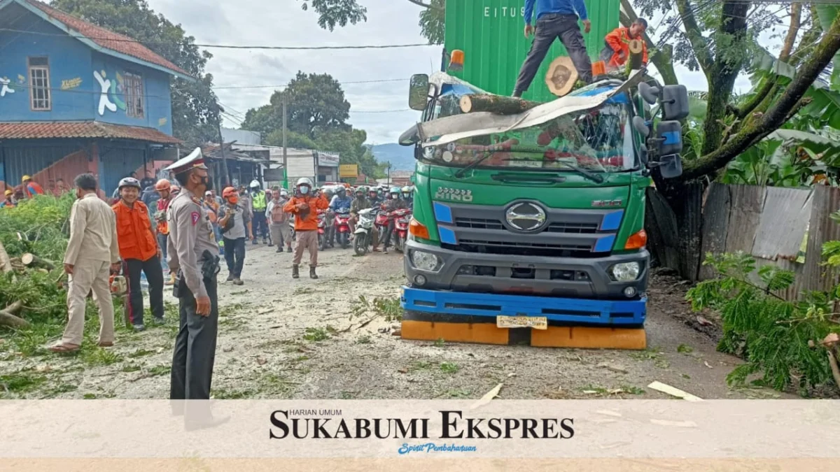 EVAKUASI: Petugas gabungan mengevakuasi pohon tumbang yang tertabrak truk kontainer di Jalan Raya Cianjur-Sukabumi di Kecamatan Sukalarang, kemarin.