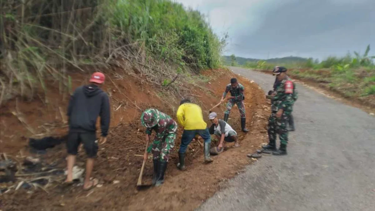 Petugas TNI saat melakukan pengerjaan jalan di Desa Tenjojaya Kecamatan Cibadak, Kabupaten Sukabumi.