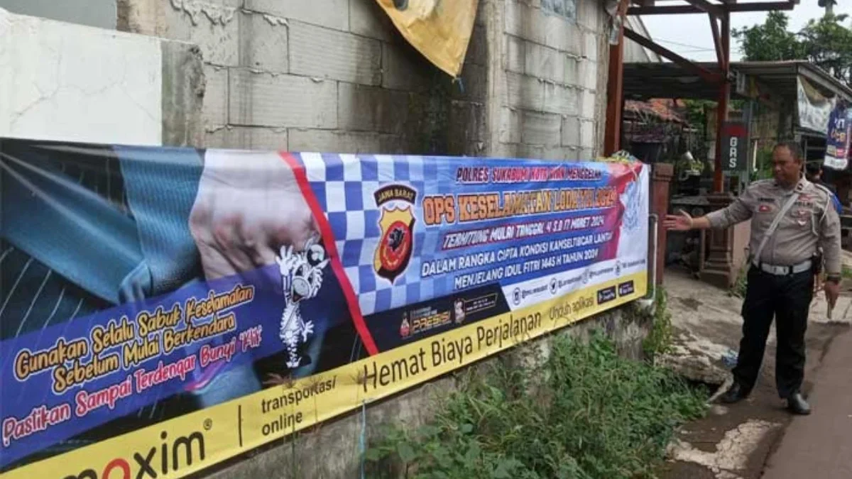 Anggota Satlantas Polres Sukabumi Kota memperlihatkan spanduk