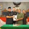 Pj Wali Kota Sukabumi Kusmana Hartadji (kiri) menyerahkan LKPj