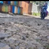 Pengendara sepeda motor melitas di ruas jalan rusak di Kelurahan Subangjaya