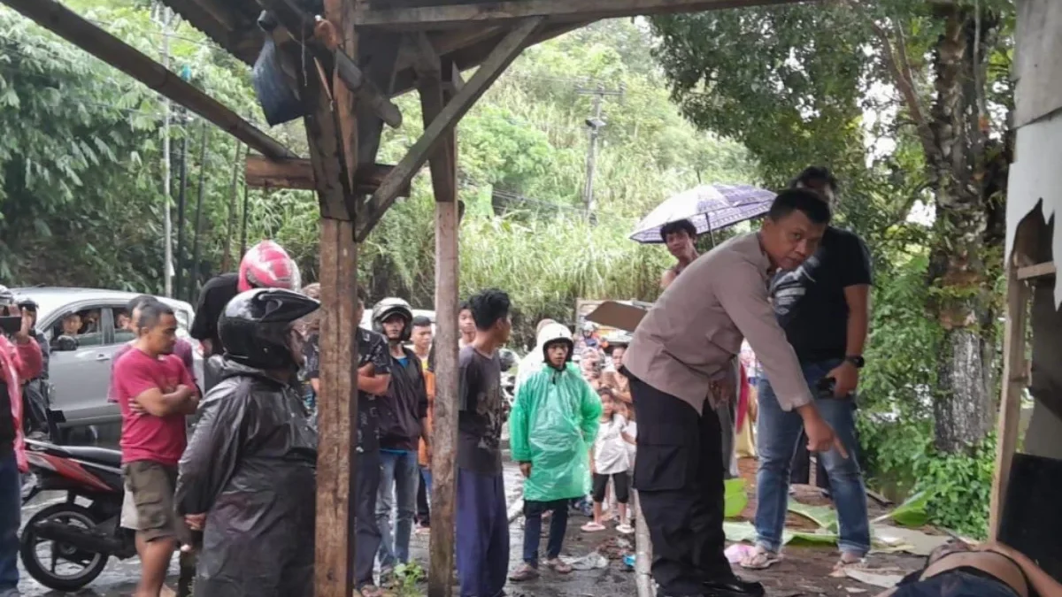 Petugas Kepolisian saat mengevakuasi Korban yang tersambar petir di sebuah warung.
